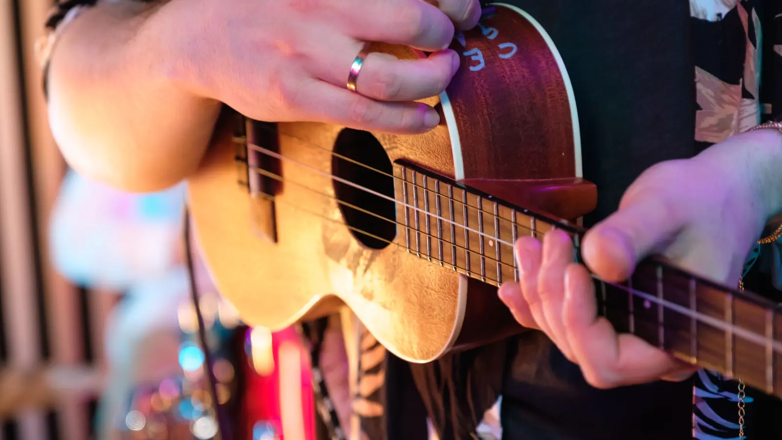 Ukulelea soitetaan konsertissa, kuvassa kädet ja kielet